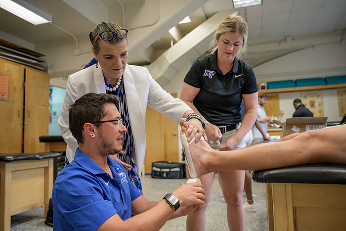 Students preparing an athlete for training